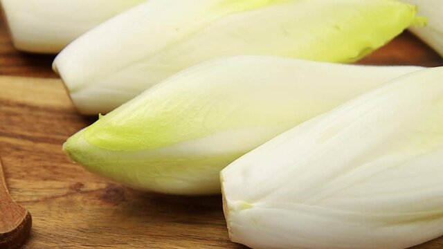 plusieurs endives crues sur une planche &agrave; d&eacute;couper