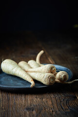 Raw Organic Parsley Roots on a wooden background. Free space for your text.