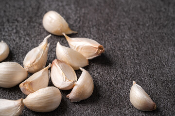 Fresh garlic cloves on black table background.