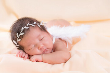 Obraz na płótnie Canvas Newborn baby girl wearing angel wing.