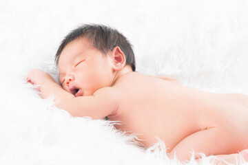 Newborn baby girl wearing angel wing.