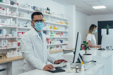 Pharmacist with protective mask on his face while working at a pharmacy