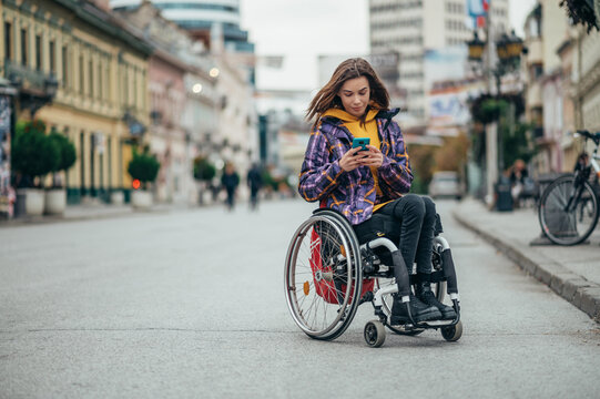 Woman with disability using a smartphone while out in the city