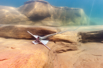 Motorboat anchor underwater with large boulders in Lake Superior Munising © Focused Adventures
