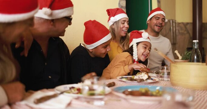 Happy latin family celebrating chirstmas and eating dinner together at home 