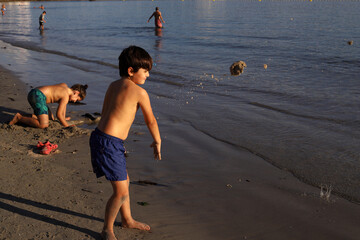 niños jugando con arena en la orilla de la playa - 468158790