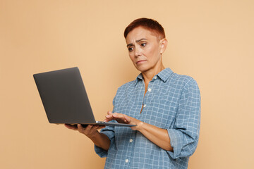 Senior ginger woman wearing shirt posing with laptop