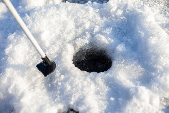 Hole In Ice. Round Hole Cut Through Ice Of Frozen Water For Fishing In Winter. 