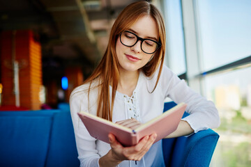 Intelligent female student in optical eyewear for provide eyes protection interested in literature...