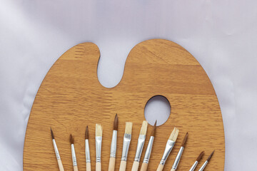 set of brushes for painting on a wooden palette