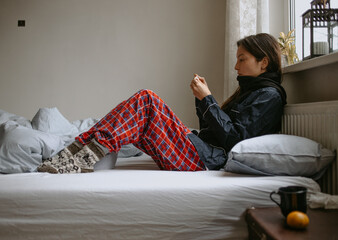 woman with the mobile phone sick at home in the bed