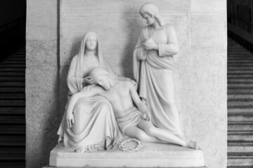 Black and white photo of marble religious statues representing Mary and other person taking care of Jesus´s dead body