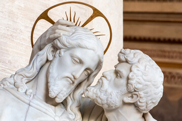 Close-up on faces of marble religious statues portraiting Judas kissing Jesus´s cheek