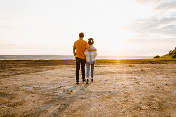 Young multiracial couple hugging while walking together