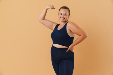 Young woman wearing sport suit smiling and showing her bicep
