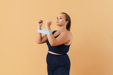 Young woman wearing sport suit doing exercise with expander stretch