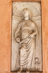 Close-up on marble religious statue carved in a monastery wall representing a medieval catholic saint