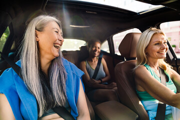 Multiracial women laughing and talking in car after practice