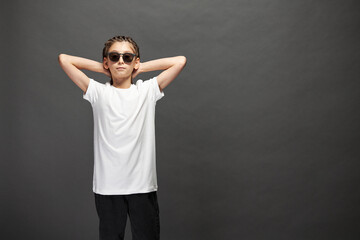 Naklejka premium Kid girl wearing white t-shirt with space for your logo or design in studio over gray background