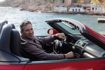 Man posing near red cabriolet, Style people drive the convertible car