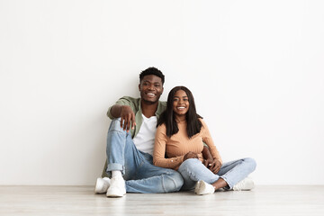 Loving black lady bonding with her happy boyfriend, white background