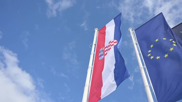 European and Croatian flag on blue skz background in slow motion