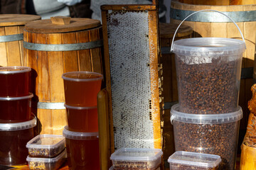 Beekeeping products. Honeycomb, honey and bee pollen in plastic buckets.