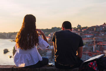Couple looking at the river at sunset with the city in the background
