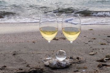 Romantic glass of white wine, on the sea beach. Wine tasting and relaxation at the resort