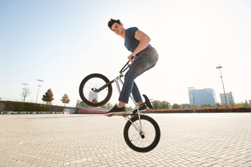 Street portrait of a bmx rider in a jump on the street in the background of the city landscape