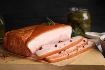 Delicious smoked bacon with rosemary and peppercorns on wooden board, closeup