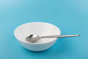 Empty plate with spoon on blue background. Flat lay Dishes for breakfast, lunch or dinner Mock up