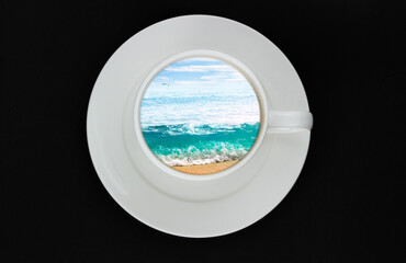 White ceramic cup with turquoise tropical sea, sky and sandy beach inside isolated on black background. Creative concept of summer holiday. Seascape inside a cup. Top view