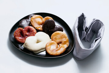 Plate of heart-shaped puff pastry cookies with chocolate, sugar and jam accompanied by a folded napkin, in Spain they are called palmeritas