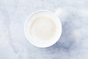 Coffee with milk on bright stone background. Top view. Close up. Copy space. 	