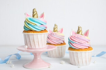 Cute sweet unicorn cupcakes on white table