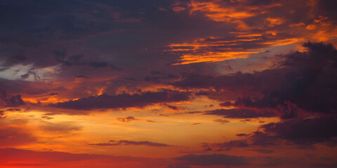 Fiery orange-red sunset sky. Dramatic sunset sky with clouds.  A real majestic sunset sky background with colorful clouds.  Beautiful sky