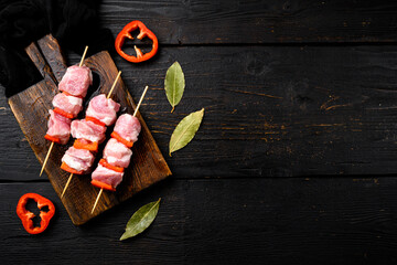 Shish kebab pork meat skewers or shashlik, top view flat lay, with copy space for text, on black wooden table background