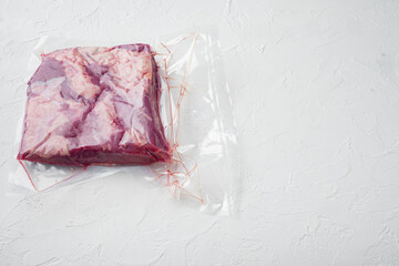 Marble beef in vacuum packed, on white stone  background , with copyspace  and space for text