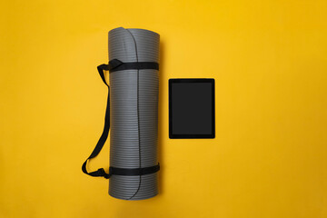 concept of online class and sports app. yoga mat next to tablet