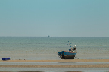 fisherman's fishing boat on sand at a fishing village beach There is an island and sea background...