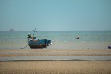 fisherman's fishing boat on sand at a fishing village beach There is an island and sea background...