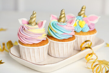 Cute sweet unicorn cupcakes and festive decor on white table
