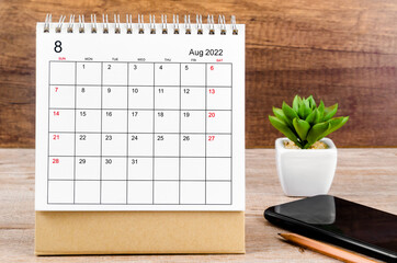 August 2022 desk calendar on wooden table.