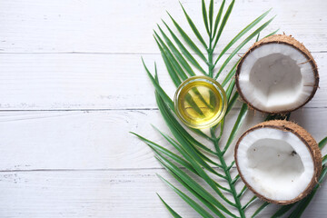 top view of slice of fresh coconut and bottle of oil on a table 
