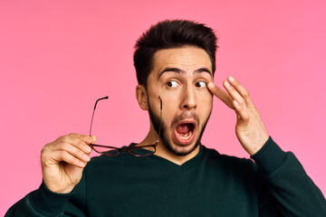 Cheerful bearded man in sweater posing pink background