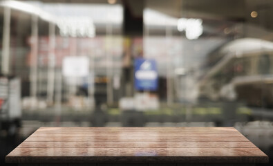 Empty wooden table top with lights bokeh on blur restaurant background.