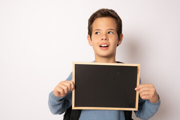 School boy holding a chalk board isolated over white background