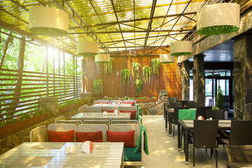 Beautiful outdoor restaurant on the veranda with a wall decorated with greenery