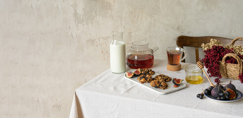 Breakfast with tea and honey, milk and cookies on linen tablecloth.Still Life. Copy space. Banner